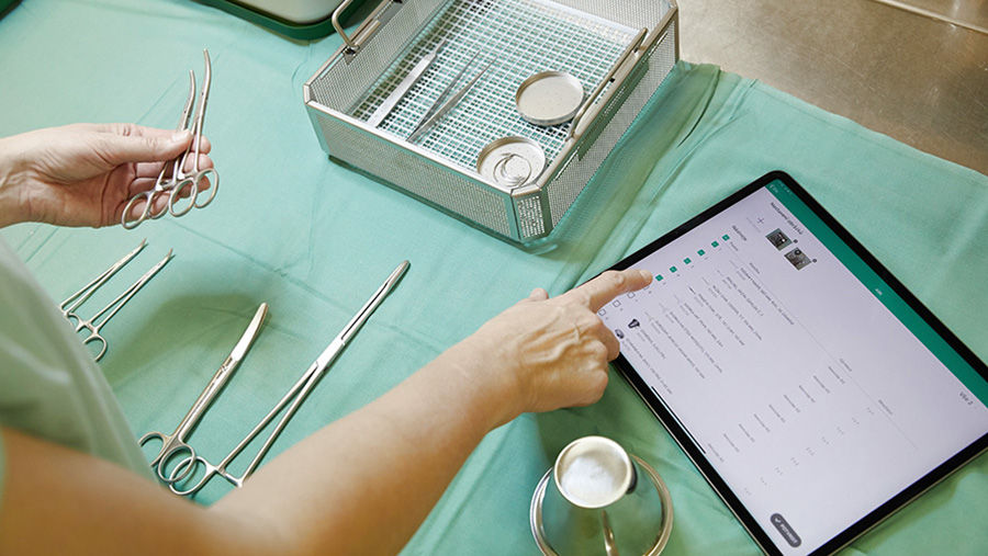 CSSD-medewerker die chirurgische instrumenten beheert met de app voor back-upvoorraadbeheer