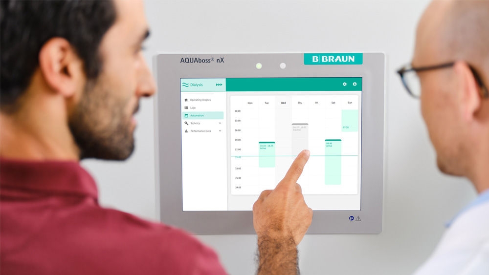 Een technicus raakt het scherm van het AQUAboss<sup>®</sup> nX-waterbehandelingssysteem aan.