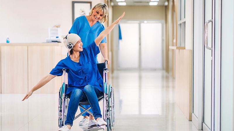 oncology-patient-with-glasses-sitting-on-the-chair-and-nurse-with-gloves-handling-cytoset-in-dayclinic