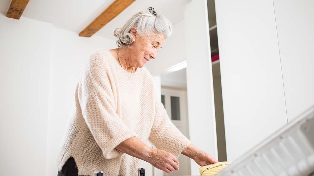 oude vrouw in badkamer en pakt toiletspullen