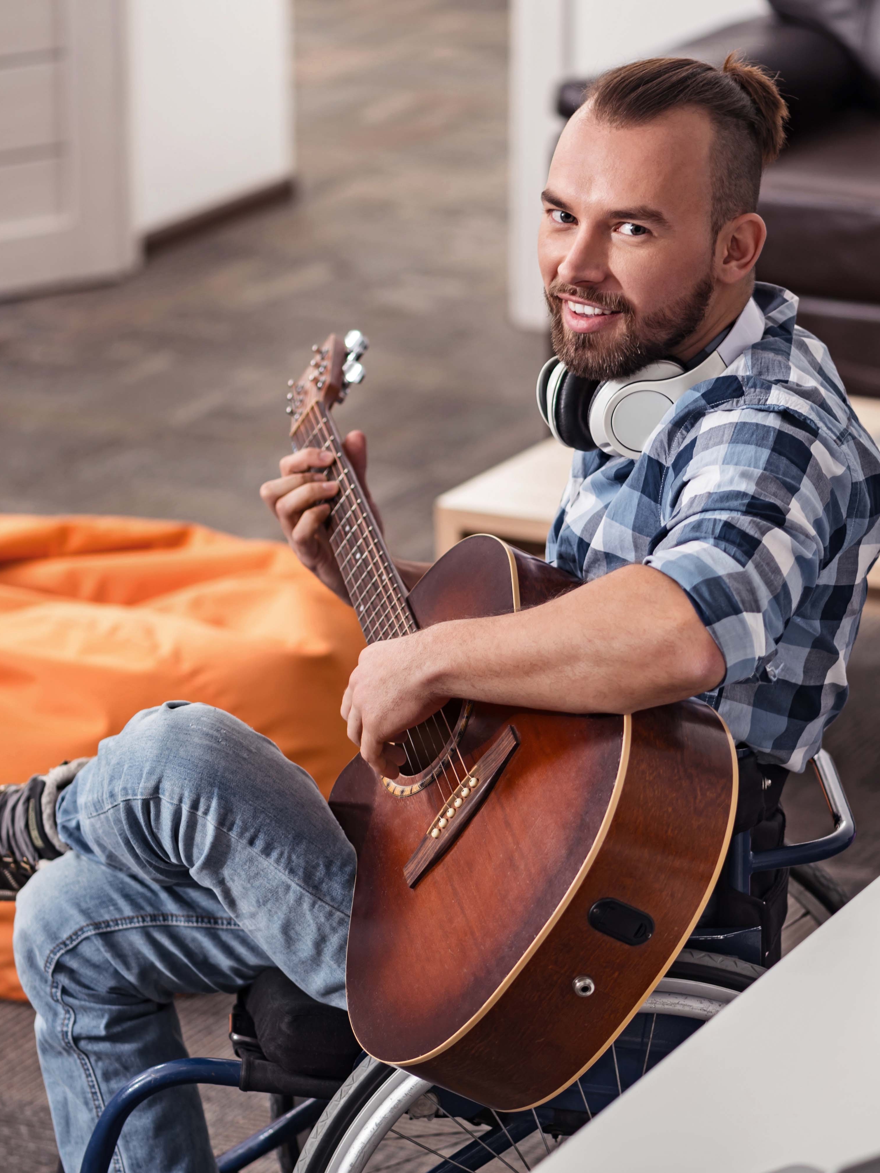 man in rolstoel met gitaar in hand