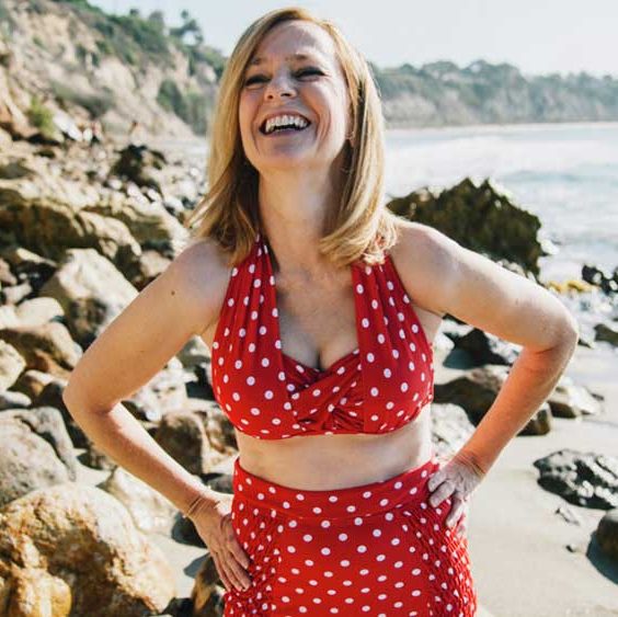 vrouw op het strand, lach in rode bikini met witte stippen